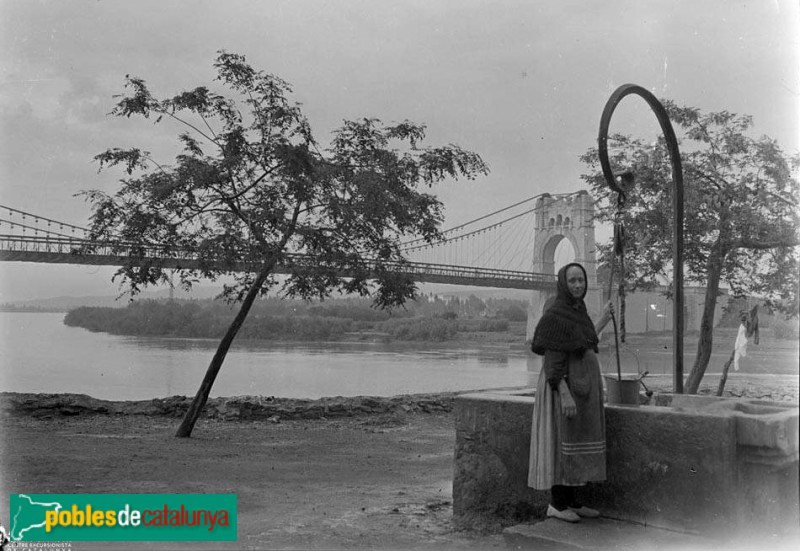 Amposta - Una dona al pou, amb el pont penjant al fons