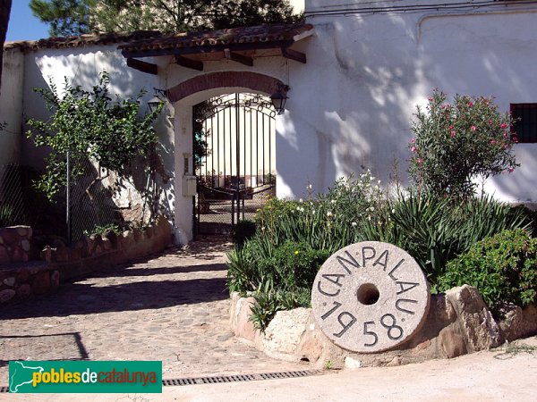 Can Palau, porta del patí que dóna accés a la Masia. La roda de molí indica la data de la darrera de les remodelacions. (Foto: Joan Sánchez Sabé, 2006) Can Palau, porta del patí que dóna accés a la Masia. La roda de molí indica la data de la darrera de les remodelacions.